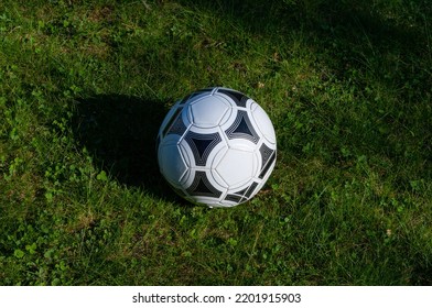 White-black soccer ball on the lush green grass of the football field close-up - Powered by Shutterstock