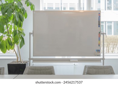 Whiteboard on window background. Close-up. green plant - Powered by Shutterstock