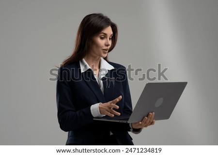 Whitecollar worker in blazer with laptop, using gesture and microphone at event