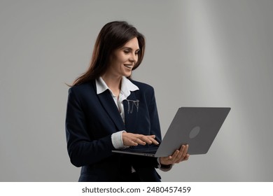 A whitecollar worker in a blazer, using technology on her laptop with a smile