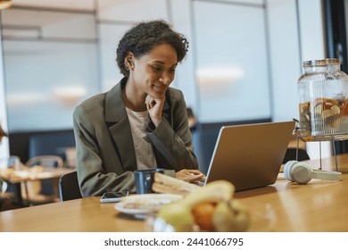 A whitecollar worker sits at a table using a laptop computer