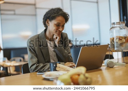 A whitecollar worker sits at a table using a laptop computer