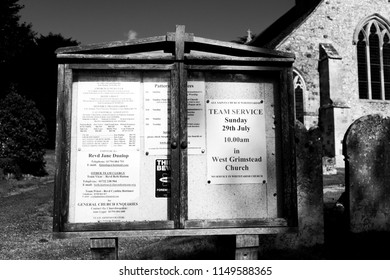 Whiteparish, Wiltshire, England - July 31, 2018: Monochrome Notice Board At All Saints Parish Church In The Church Of England Diocese Of Salisbury, Building Dating Back To Circa 1190