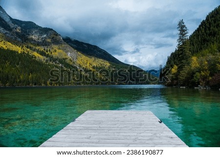 Whiteswan Lake in Provincial Park, Kootenay Rockies, British Columbia, Canada. View of dock on green water, mountain forest on cloudy autumn day