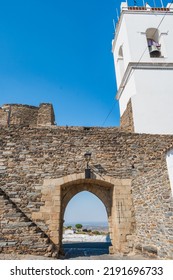 Whitewashed Campanile With Bell And Schist Stone Wall With Pointed Arch Of The Village Gate With Alqueva Landscape On The Horizon, Monsaraz PORTUGAL