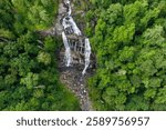 Whitewater Falls with falling down clear water from rocky boulders between green lush woods in Nantahala National Forest, North Carolina, USA