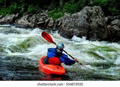 A whitewater kayaker braces in fast moving water on the river
