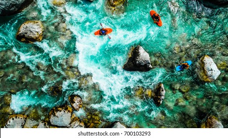 Whitewater kayakers on the Emerald waters of Soca river, Slovenia, are the rafting paradise for adrenaline seekers and also nature lovers, aerial view.