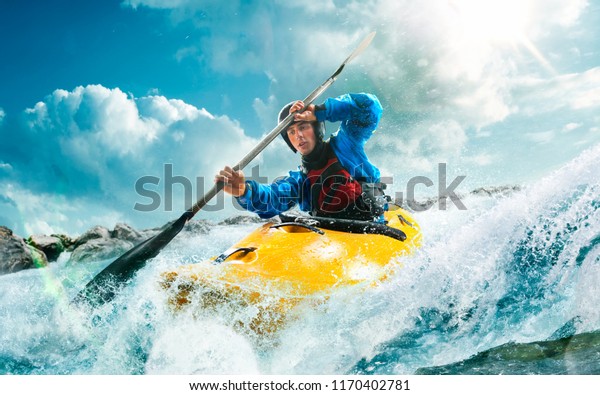 Whitewater kayaking, extreme kayaking. A guy in a\
kayak sails on a mountain\
river