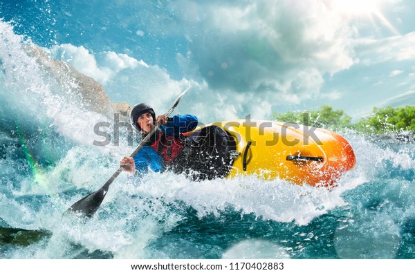 Whitewater kayaking, extreme kayaking. A guy in a\
kayak sails on a mountain\
river