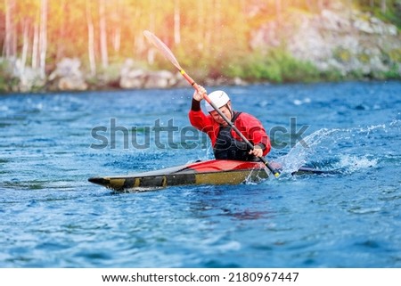 Whitewater kayaking, extreme sport rafting. Guy in kayak sails mountain river.