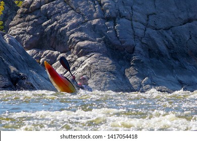 Whitewater Kayaking On Fast Moving Water Of Mountain River Among The Rapids, Extreme Water Sport. Kayak Freestyle On Whitewater. Man In Red Kayak