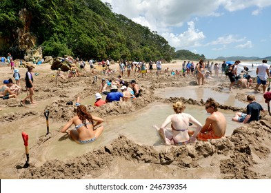WHITIANGA, NZL - Jan 20 2015:Visitors making small hot water pools in Hot Water beach.it one of the most popular geothermal attractions in New Zealand, about 700,000 people visit the beach annually.