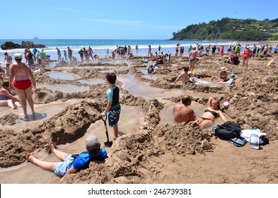 WHITIANGA, NZL - Jan 20 2015:Visitors making small hot water pools in Hot Water beach, one of the most popular geothermal attractions in New Zealand, about 700,000 people visit the beach annually.