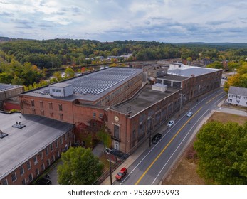 Whitin Machine Works Mill aerial view on Main Street in fall with foliage in historic village of Whitinsville, town of Northbridge, Massachusetts MA, USA. 