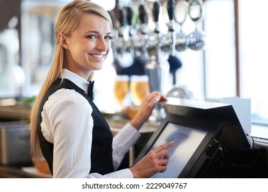 I am a whiz on this till. Beautiful barmaid standing by a till smiling as she rings through a round of drinks. - Shutterstock ID 2229049767