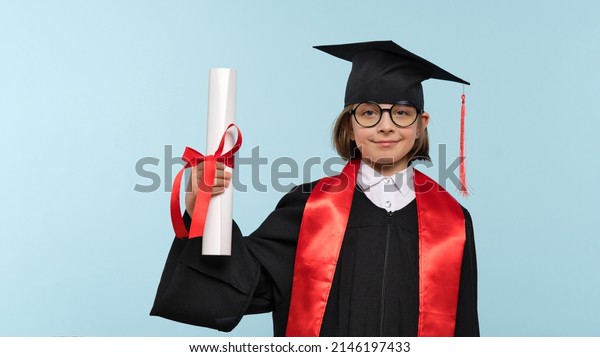 Whizz kid 9-11 year girl wearing graduation cap,\
round eyewear and ceremony robe with certificate diploma on light\
blue background. Graduate celebrating graduation. Education\
Concept. Success