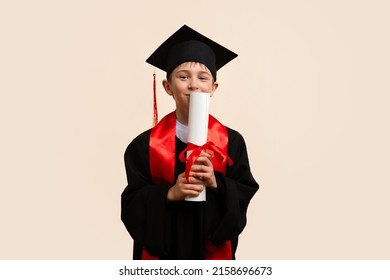 Whizz kid 9-11 year wearing graduation cap and ceremony robe Kissing Paper Certificate of Education. Еlementary school graduate boy with certificate diploma tied with red ribbon in studio. - Shutterstock ID 2158696673