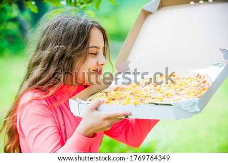 who cares about diet. her favorite food. junk food concept. happy child hold big pizza. meal delivery in time. hungry kid eating pizza. looking tasty and perfect. feel real hunger.