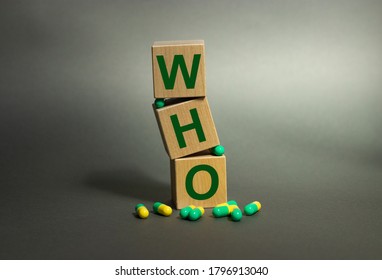 Who On Wooden Cubes With Capsules On A Gray Background. World Health Organisation. Concept Of Institutions And Regulations.