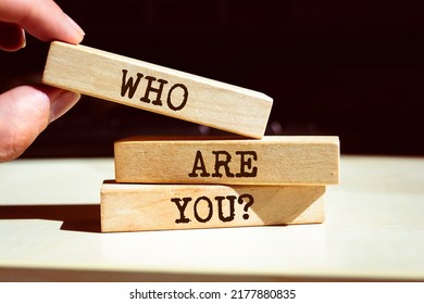 Who Are You? Symbol. Businessman Hand. Wooden Blocks With Words 'Who Are You?'.