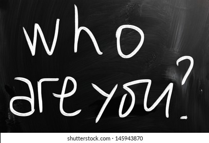 "Who are you" handwritten with white chalk on a blackboard