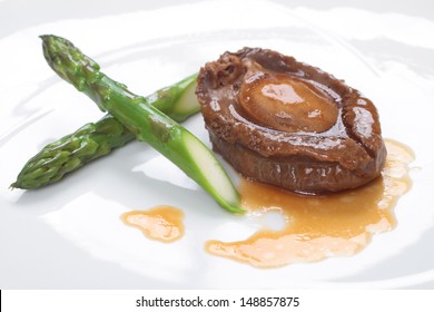 Whole abalone and asparagus