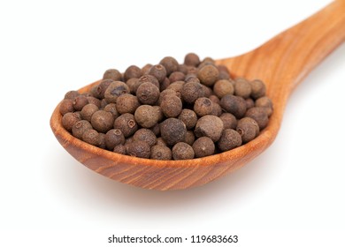 Whole Allspice Berries In A Wooden Spoon