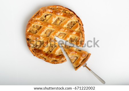 Whole apple pie, top view, a piece is taken out with a chrome cake server