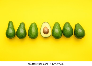Whole avocados and one half on color background. Concept of uniqueness