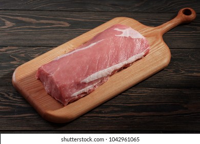 Whole Boneless Pork Loin Without Fat. Pork Tenderloin On A Cutting Board On A Dark Table