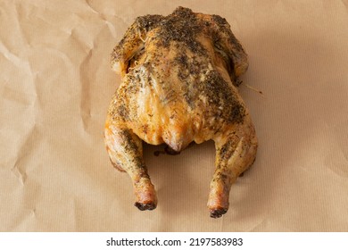 Whole Chicken Coated In Mixed Herbs Roasted In An Oven. On A Brown Paper Background