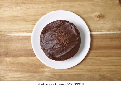 A Whole Chocolate Fudge Layer Cake On A Wooden Kitchen Counter Background