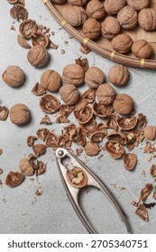 Whole and cracked walnuts and nutcracker