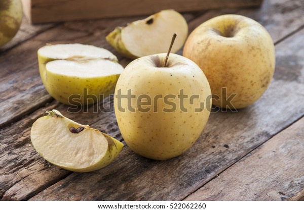 Whole and Cut in Half Apple lying on Textured\
Weathered Wooden Table