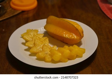 Whole and cut starfruit on plate