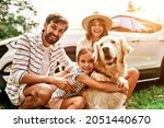 The whole family came to nature for the weekend. Mom and Dad with their daughter and a Labrador dog are standing near the car. Leisure, travel, tourism.