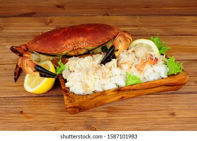 Whole Fresh Cooked Brown Crab And Fresh Meat In A Wood Dish On A Wooden Background With Lemon