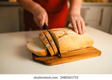 Whole grain bread put on kitchen wood plate with a chef holding gold knife for cut. Fresh bread on table close-up. Fresh bread on the kitchen table The healthy eating and traditional bakery concept - Powered by Shutterstock