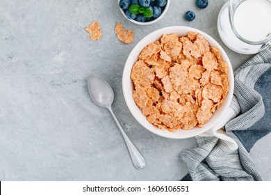 Whole Grain Breakfast Cereal Flakes With Fresh Blueberries And Milk. Healthy Breakfast Bowl. Top View, Copy Space