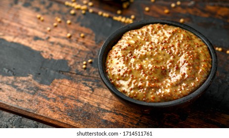 Whole Grain Mustard In Bowl On Wooden Table.