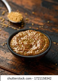 Whole Grain Mustard In Bowl On Wooden Table.