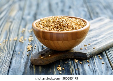 Whole Grain Oats In A Wooden Bowl On An Old Cutting Board.