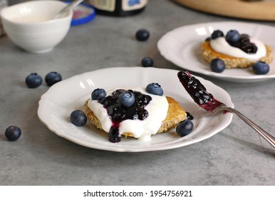 Whole Grain Pancakes With Blueberries,joghurt And Jam On White Plate