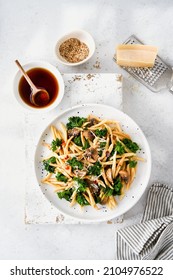 Whole Grain Pasta With Kale, Mushrooms, Parmezan Cheese In White Plate On Light Background. Vegetarian Healthy Diet Concept. Recipe Step By Step. Copy Space For Text. Top View.