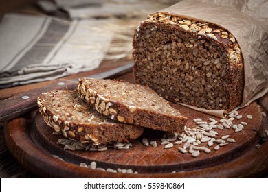 Whole Grain rye bread with seeds on a wooden board. - Shutterstock ID 559840864