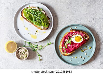 Whole grain toast with cream cheese, avocado, beetroot hummus, seeds, egg and microgreens (sprouted pea sprouts) on a light gray background. Healthy food concept. - Powered by Shutterstock