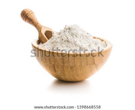 Whole grain wheat flour in bowl isolated on white background.