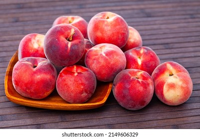 Whole and half fresh red peaches on wooden table. Healthy vegetarian ingredient - Shutterstock ID 2149606329