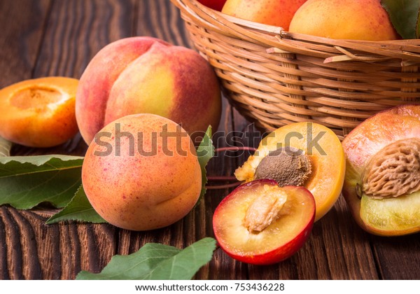 Whole\
and half peaches, plums and apricots in a\
basket